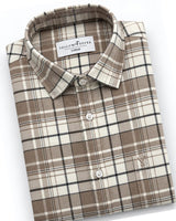 A folded long-sleeve plaid button-down shirt by YellowPeppers in a beige, brown, and black check pattern, shown on a clean white background.