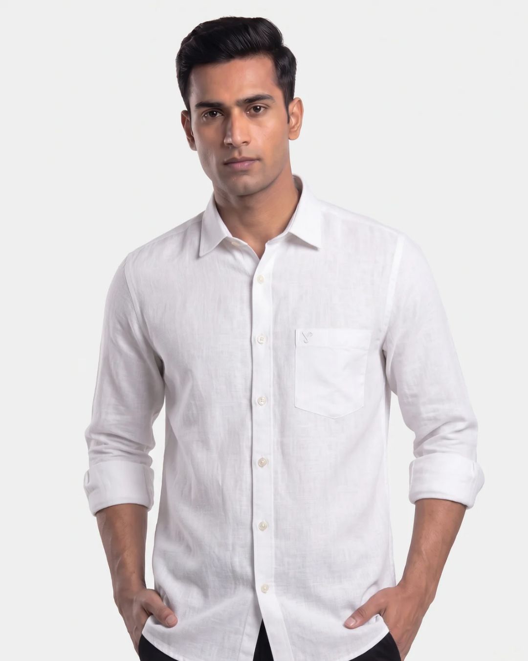 A man wearing a white long-sleeve linen shirt with a chest pocket, shown from the waist up against a light gray studio background.