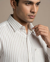 Man wearing a white striped shirt against a beige background
