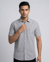 Man wearing a black and white striped shirt on a gray background