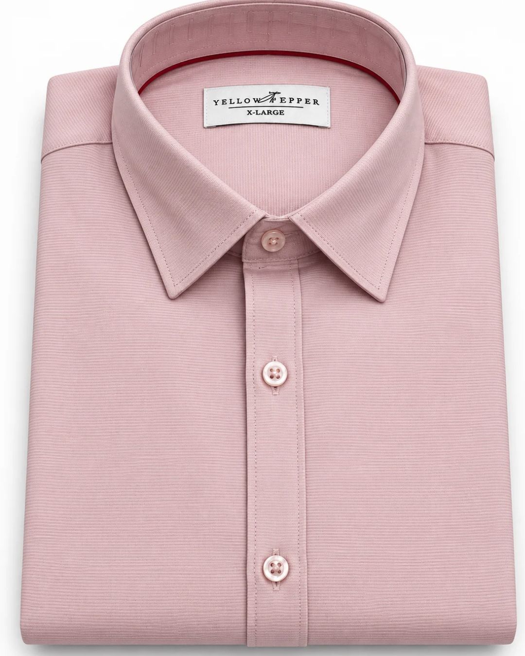 A folded light pink dress shirt with a classic collar and button-down front, featuring a visible 'Yellow Pepper Paris' brand label inside the collar.
