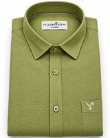A folded olive green long-sleeve dress shirt with a pointed collar, three-button placket, and a left chest pocket featuring a small embroidered logo, shown on a white background.