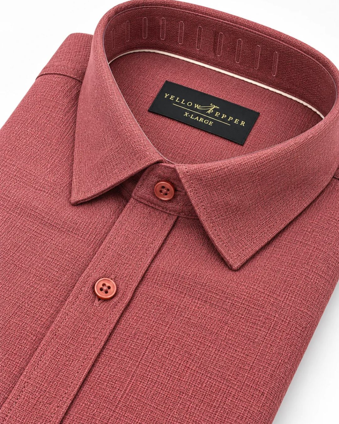 A close-up of a men's collared dress shirt in a dusty rose or muted mauve color, featuring a black neck label that reads 'YELLOW PEPPER XLARGE'.
