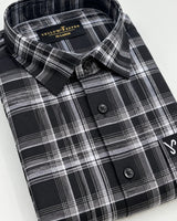 A folded long-sleeve plaid button-up shirt in black, gray, and white, with a visible Yellow River brand label inside the collar.