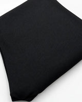 A folded black ribbed knit fabric garment, likely a sweater or knit top, shown on a plain white background.