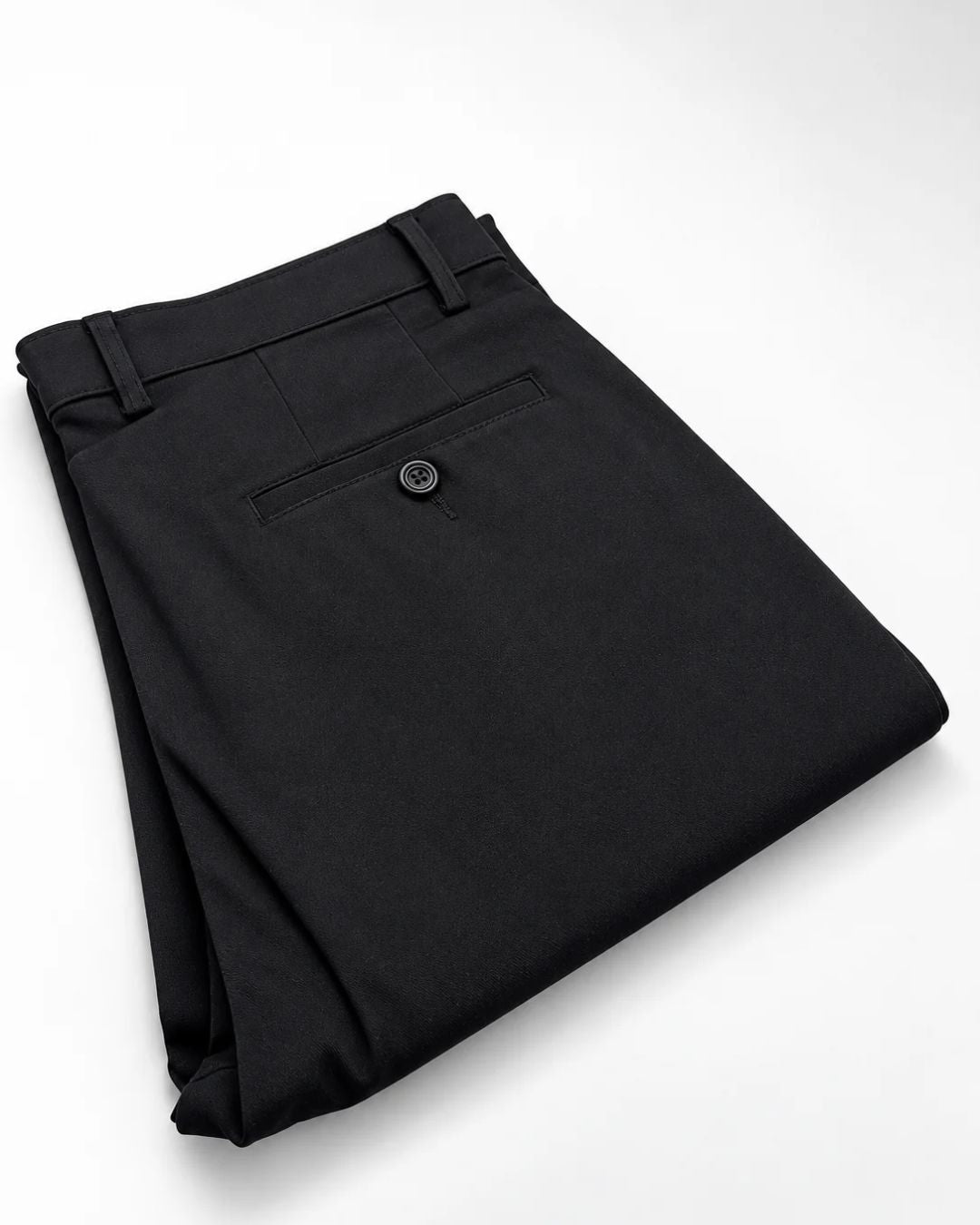 A pair of folded black dress pants with a buttoned welt pocket on the back, displayed on a clean white background.